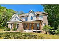 Charming two-story brick home with a welcoming front porch and manicured lawn at 2870 Willow Wisp Way, Cumming, GA 30040