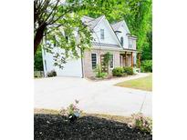 Two-story brick home with white siding, landscaped yard, and a driveway leading to an attached two-car garage at 2870 Willow Wisp Way, Cumming, GA 30040