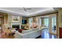 Bright living room featuring fireplace, hardwood floors, and doors leading to sunroom at 470 Ansley Walk Ne Ter, Atlanta, GA 30309