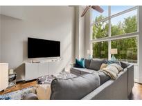 Bright living room with high ceilings, large windows, and comfortable gray sectional sofa at 1356 Peter Haughton Nw Way, Atlanta, GA 30318