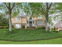 Charming stone and stucco home with mature trees and lush landscaping at 454 Langley Oaks Dr, Marietta, GA 30067