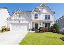 Charming two-story farmhouse-style home with white siding, a manicured lawn and beautiful landscaping at 146 Citrine Way, Acworth, GA 30101