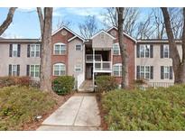 Inviting condo complex featuring brick accents, mature landscaping, and a charming walkway at 384 Teal Ct, Roswell, GA 30076
