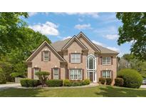 Charming brick two-story home featuring manicured landscaping, a gabled roof, and a grand entryway with large windows at 891 Berryman Pl, Lawrenceville, GA 30045