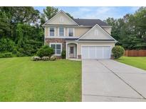 Charming two-story home with stone accents, manicured lawn, and attached two-car garage at 145 Redsage Rdg, Atlanta, GA 30349