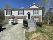 Charming home with a two-car garage, brick accents, and a welcoming front entrance with well-maintained landscaping at 2490 Riverwood Spg, Ellenwood, GA 30294