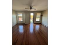 Bright living room featuring hardwood floors, ceiling fan, and sliding doors at 898 Oak St # 3412, Atlanta, GA 30310