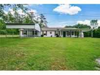 Charming single-story home with covered parking and a sprawling green lawn, perfect for outdoor activities at 7307 Banks Mill Rd, Douglasville, GA 30135