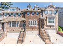 Attractive brick townhome featuring multi-car garage and brick staircase leading to the front entrance at 1382 Doublegate Ne Dr, Atlanta, GA 30319