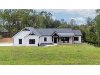 Charming white brick home with black accents, well-manicured lawn and covered porch at 16 Mountain Creek Ne Trl, Fairmount, GA 30139