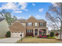 Charming brick home featuring a well-manicured lawn and a cozy front porch, perfect for relaxing at 2710 Irwin Ct, Cumming, GA 30041