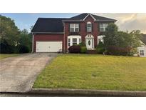 Charming two-story brick home featuring a well-manicured lawn and a two-car garage at 3511 Autumn Farm Ter, Buford, GA 30519