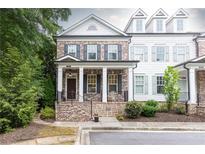 Charming two-story brick home featuring a cozy front porch, black shutters, and manicured landscaping at 555 Letchas Ln, Alpharetta, GA 30009