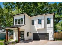 Modern two-story home featuring white vertical siding, black trim, and an attached garage at 156 Martha Ne Ave, Atlanta, GA 30317