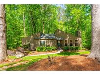 Charming home nestled among mature trees with a well-maintained lawn and inviting walkway to the front entrance at 3925 Rock Mill Pkwy, Marietta, GA 30062