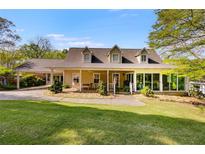 Charming tan home featuring a lush green lawn and a convenient covered carport at 317 Ellenwood Dr, Bowdon, GA 30108