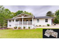 Charming white brick home with a spacious covered porch and manicured lawn at 9680 Ephesus Church Rd, Villa Rica, GA 30180