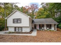 Charming two-story home featuring a white brick and vinyl exterior with a cozy front porch and a well-maintained lawn at 2377 Emory Ln, Marietta, GA 30068