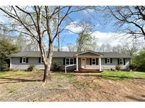 Charming one-story home with gray siding, a covered porch, and a well-maintained front yard at 326 Old Farm Road, Woodstock, GA 30188