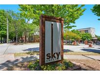 Sky Lofts brick and metal sign with colorful plants in the foreground of a landscaped community at 898 Oak Sw St # 3207, Atlanta, GA 30310