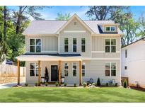 Charming two-story home with light gray siding, black trim, manicured lawn, and welcoming front porch at 2553 Creekwood Ter, Decatur, GA 30030