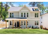 Charming two-story home featuring a welcoming front porch and a well-manicured lawn at 2553 Creekwood Ter, Decatur, GA 30030