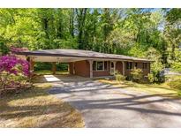 Charming brick home with a covered parking area and lush, mature landscaping in a serene, wooded setting at 470 Hunnicutt Se Rd, Mableton, GA 30126