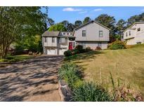 Charming two-story home with a manicured front lawn, red door, and attached two-car garage at 1189 Norfolk Nw Dr, Acworth, GA 30102