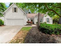 Charming home featuring a two-car garage, manicured lawn, and mature landscaping at 6250 Bannerhorn Run, Alpharetta, GA 30005