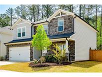 Charming two-story home with a stone facade, well-maintained lawn, and attached two-car garage at 660 Stately Dr, Woodstock, GA 30188