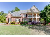 Charming two-story brick home with a double balcony and a beautifully landscaped front yard and a traditional design at 2930 Aquitania Ln, Cumming, GA 30040