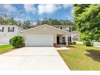 Charming two-story home featuring a well-manicured lawn and an attached two-car garage at 1023 Saint Augustine Pkwy, Locust Grove, GA 30248