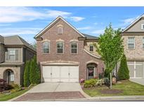 Charming two-story brick home featuring a two-car garage and a beautifully landscaped front yard at 1908 Weston Ln, Tucker, GA 30084