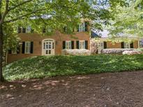 Charming brick home featuring a well-manicured lawn and a classic white-framed arched entryway at 3573 Turtle Cove Se Ct, Marietta, GA 30067