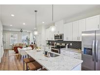 Modern kitchen with white cabinets, stainless steel appliances, and a large island with bar seating at 1095 Tucker Ave # 207, Atlanta, GA 30310