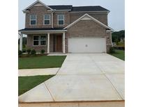 Charming two-story brick home with a manicured lawn and a two-car garage at 126 Kenney Way, Locust Grove, GA 30248