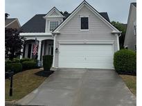 Charming two-story home with a gray exterior, manicured lawn, and a two-car garage at 1620 Diplomat Dr, Cumming, GA 30041
