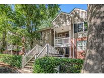 Charming townhome with a brick facade, featuring a private balcony and lush landscaping at 446 Teal Ct, Roswell, GA 30076