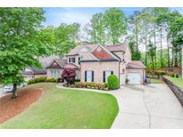 Charming brick two-story home with a manicured front yard and two car garage at 1738 Honey Tree Pl, Hoschton, GA 30548
