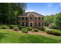 Traditional two-story brick home with mature landscaping and a well-manicured lawn at 4423 Windsor Oaks Cir, Marietta, GA 30066