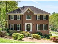 Two-story brick home featuring a symmetrical design, complemented by lush landscaping and a well-manicured lawn at 4423 Windsor Oaks Cir, Marietta, GA 30066