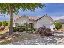 Charming single-story home with well-manicured landscaping, bench, and a two-car garage at 327 Stone Valley Xing, Canton, GA 30114