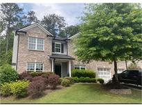 Charming two-story brick home featuring manicured landscaping, a covered entryway, and an attached garage at 808 Wade Farm Dr, Austell, GA 30168