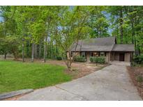 Charming home with a well-maintained front yard and driveway, surrounded by mature trees at 6693 Doublegate Ln, Rex, GA 30273