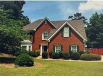Charming two-story brick home with well-manicured lawn and lush landscaping at 990 Lilac Arbor Rd, Dacula, GA 30019