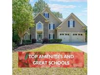 Charming two-story home features a well-manicured lawn, stone accents, and a two-car garage at 1354 Benbrooke Nw Ln, Acworth, GA 30101