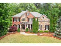 Charming brick and stone home with a well-manicured lawn and inviting walkway at 893 Paces Farm Sw Trl, Marietta, GA 30064