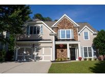 Charming two-story home featuring a stone facade, blue shutters, manicured lawn, and a two-car garage at 36 Evergreen Way, Dallas, GA 30157
