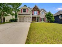 Charming two-story home featuring a two-car garage, stone accents, red shutters, and a well-manicured lawn at 36 Evergreen Way, Dallas, GA 30157