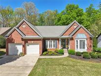 Charming brick home with manicured lawn, two-car garage, and inviting front entrance at 1670 Bookhout Dr, Cumming, GA 30041